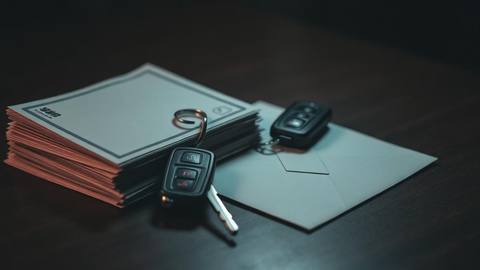 Stack of bills next to a set of car keys